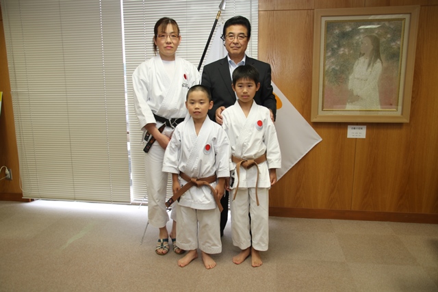 空手の道着を着た若林さん清水さん土屋さんと市長が並んで記念撮影をしている写真