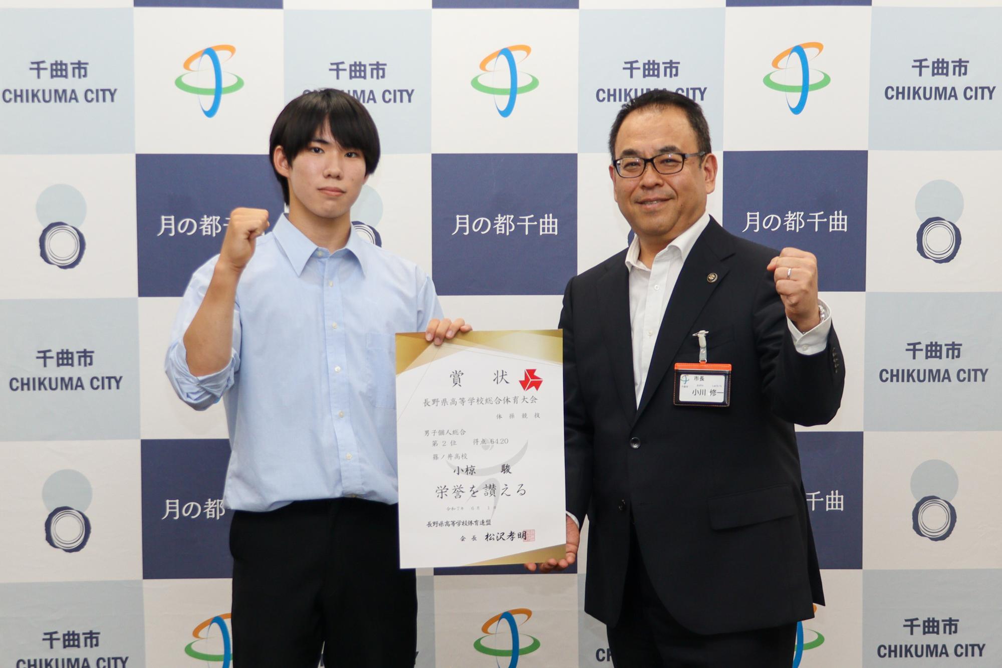 個人総合の賞状を持ちながらガッツポーズをする小椋さん(左)と小川市長(右)