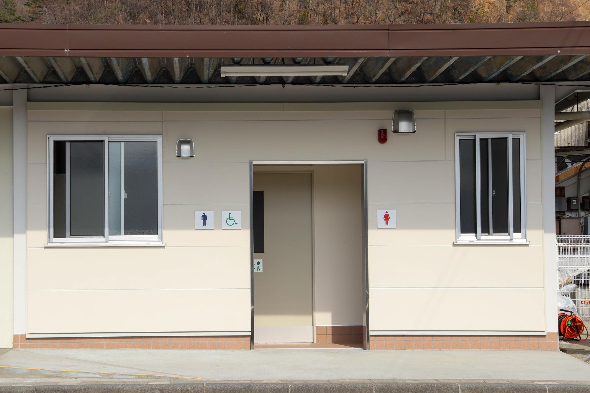 改修工事後トイレ外観を正面から撮影、右側から女子トイレ、バリアフリートイレ、男子トイレ