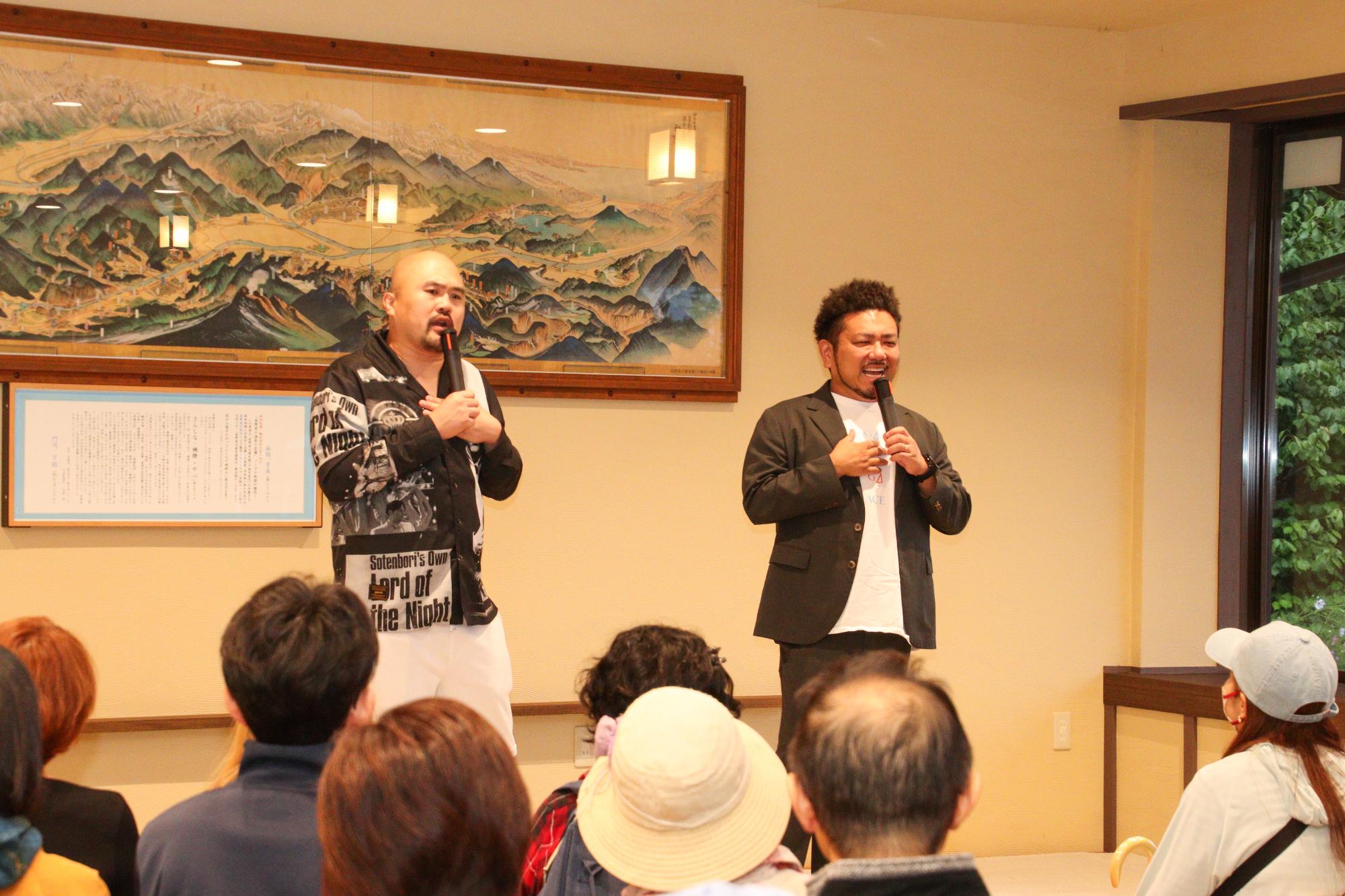 観客の前で話す鬼越トマホークの2人、(右)金ちゃん、(左)千曲市出身の良ちゃん