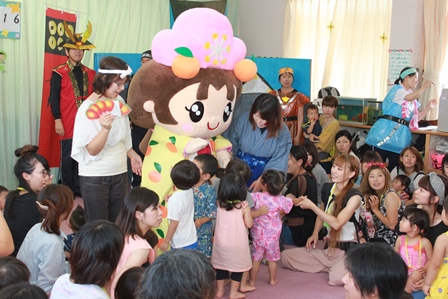 着ぐるみのキャラクターの周りに子供たちがたくさん集まっている写真