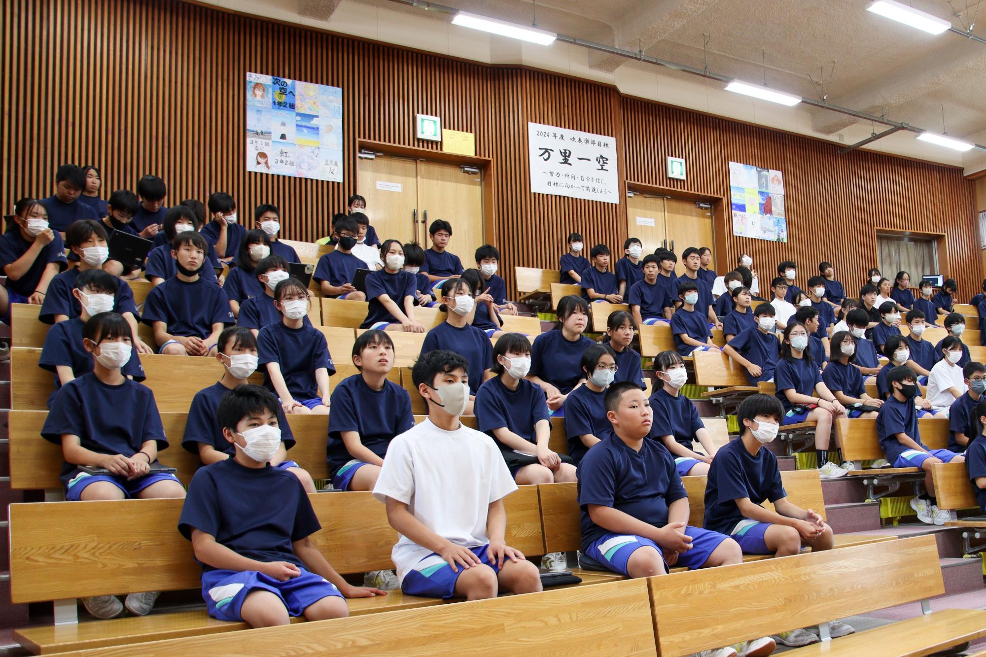 ワークショップの説明を聞く屋代中学校2年生の生徒たち