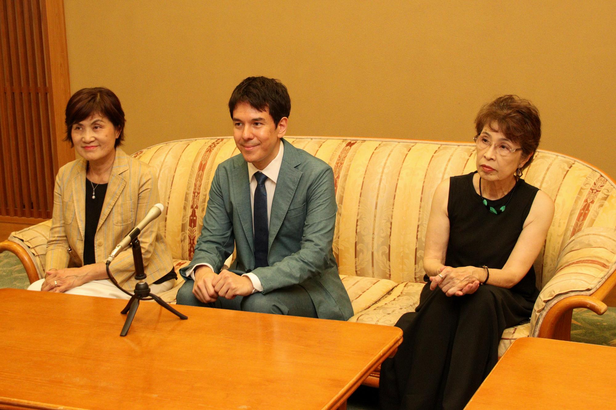 記者会見をする実行委員会(両脇)と金子さん(中央)