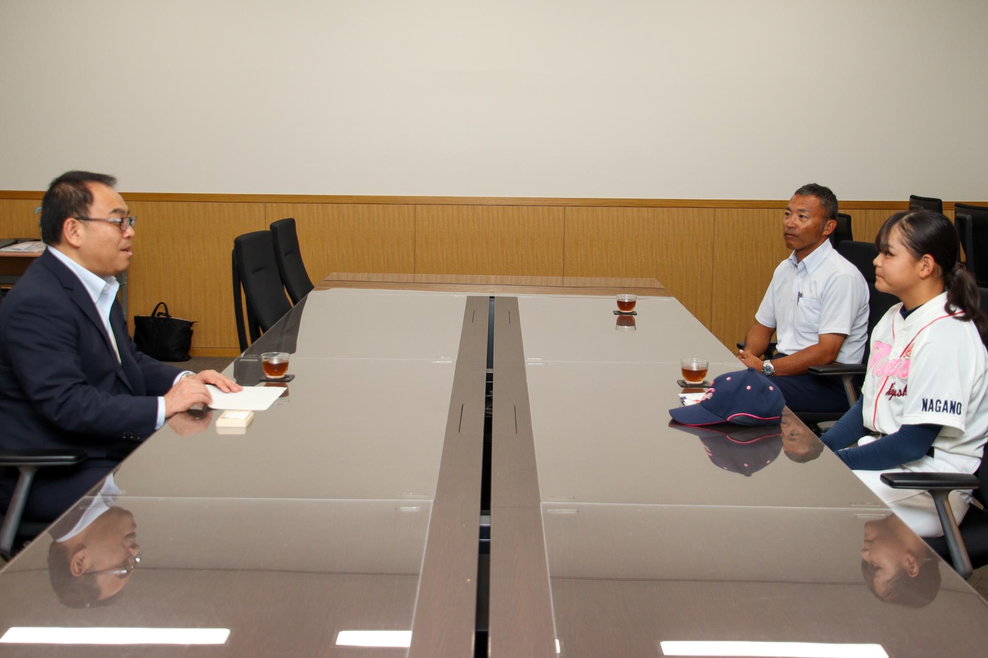 表敬訪問で懇談をする小川市長(左)と高橋さん(右手前)、監督(右奥)