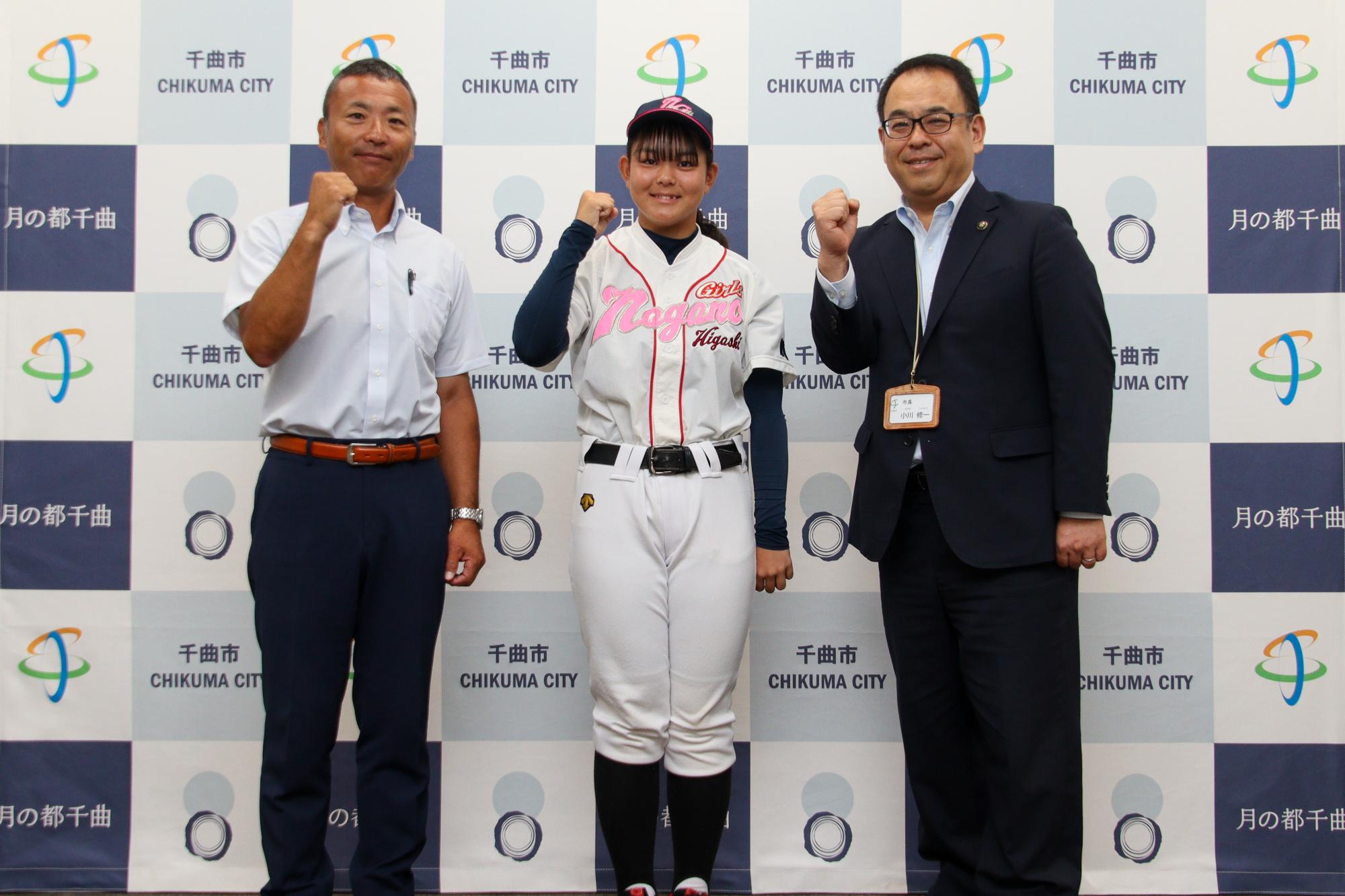 ガッツポーズをする高橋さん(中央)と小川市長(右)、監督(左)