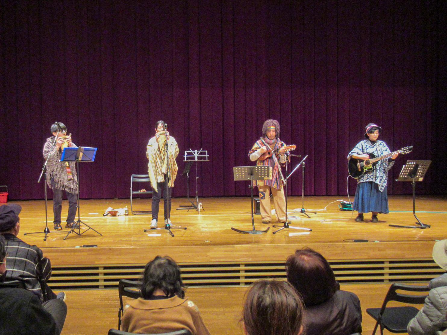 民謡音楽をステージ演奏する発表者と見学者