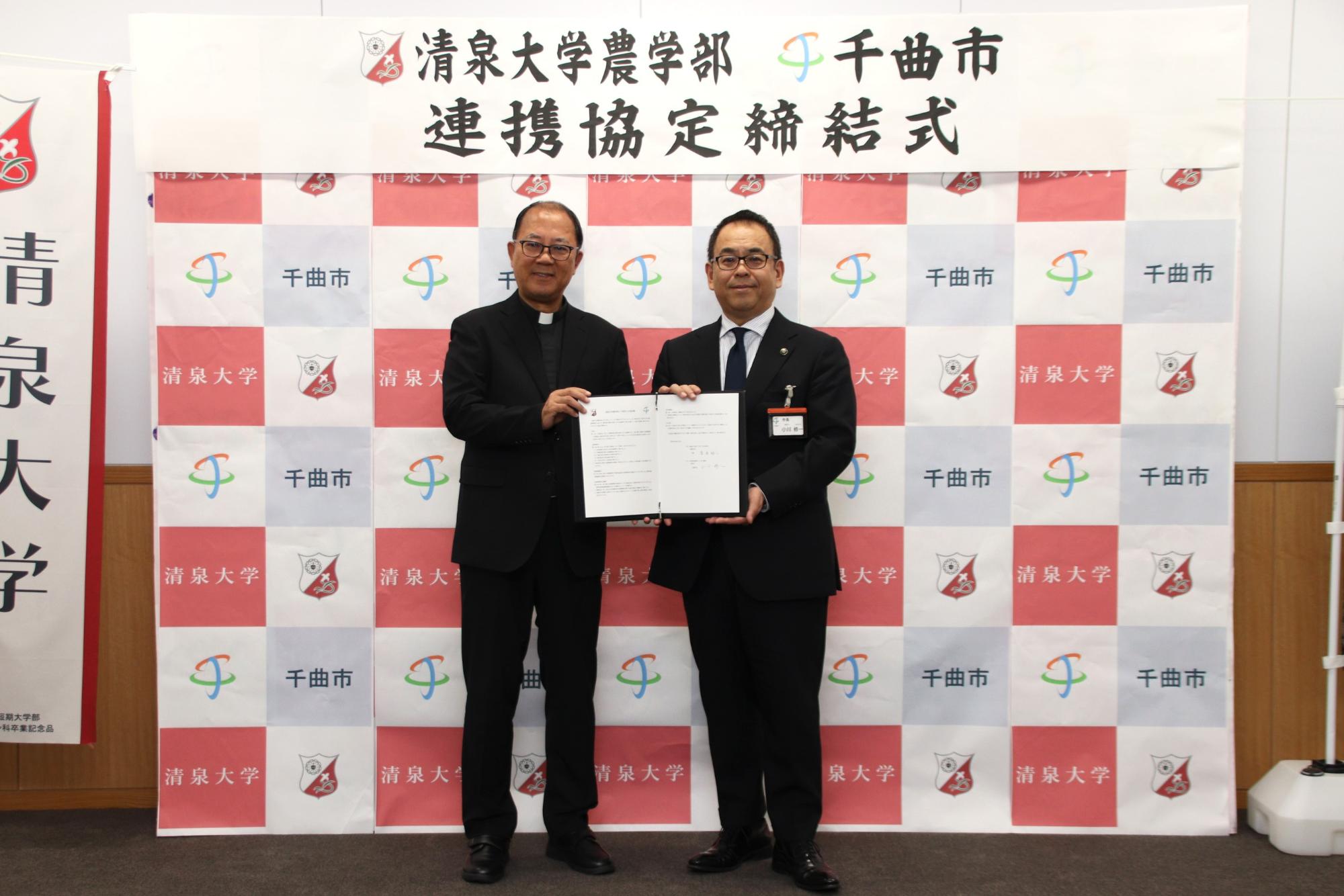 記念写真(左:清泉大学菅原裕二学長、右:小川修一市長)