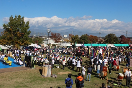 公園の会場で大勢の人々が祭りを楽しむ写真