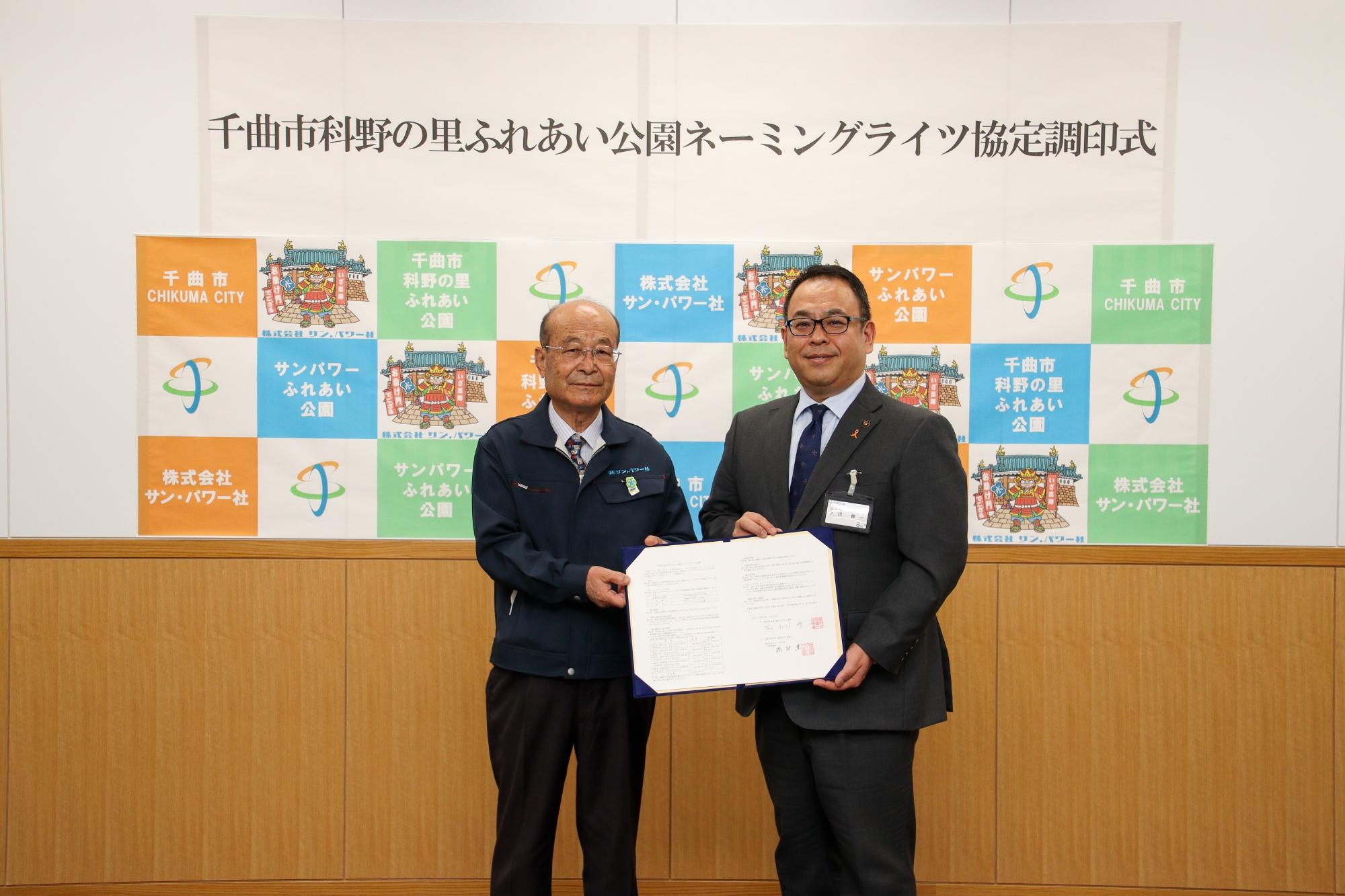 協定書を持ち記念撮影する小川市長と株式会社サン・パワー社の橋詰代表取締役