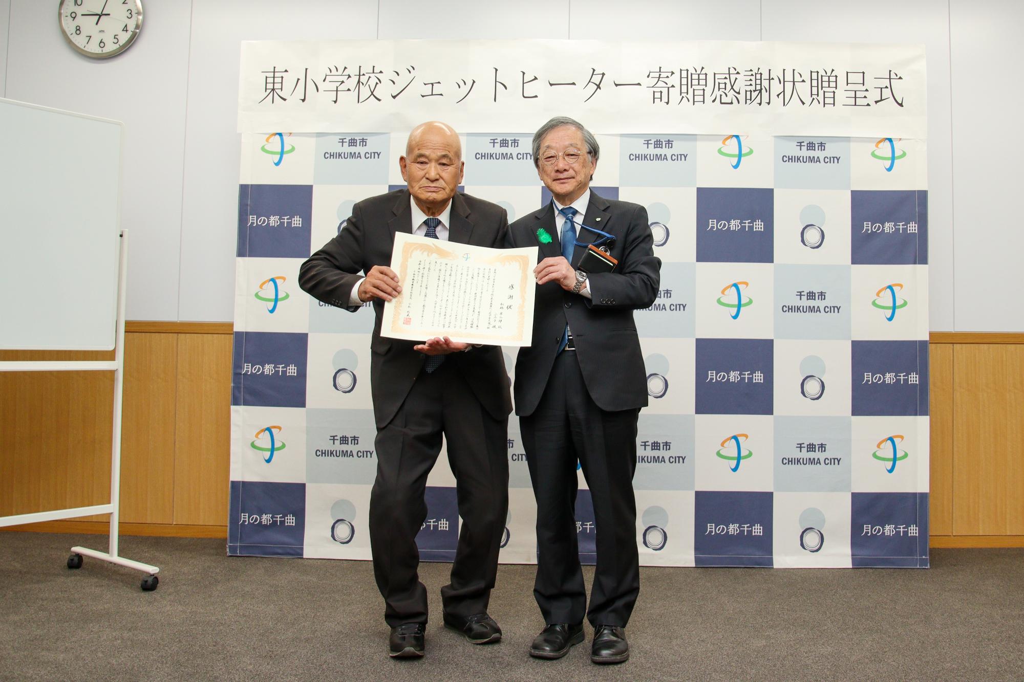 感謝状をもって記念撮影をする松林さん(左)と小松教育長(右)