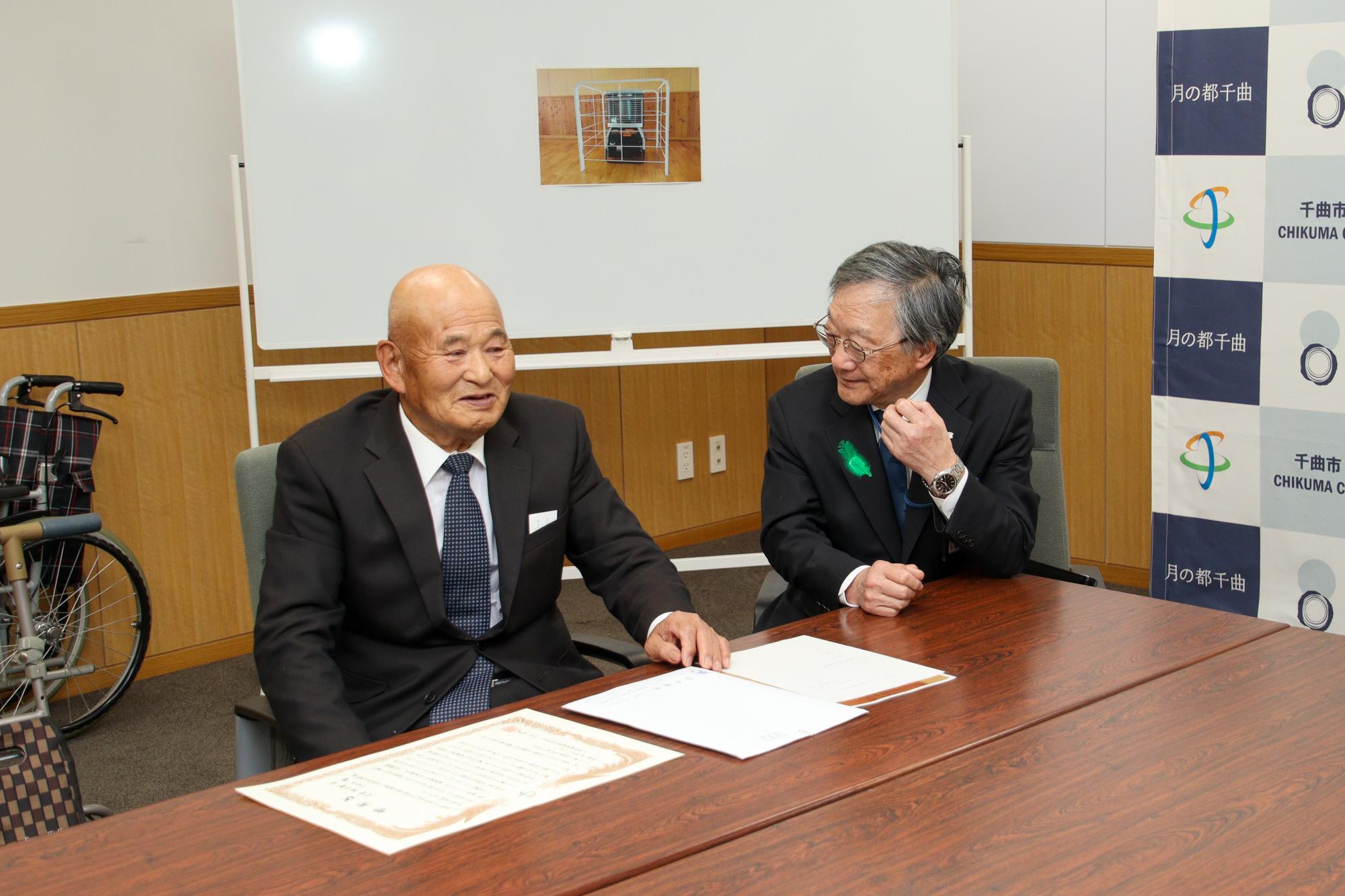 日頃の教育支援に感謝を伝える小松教育長(右)と話を聞く松林さん(左)
