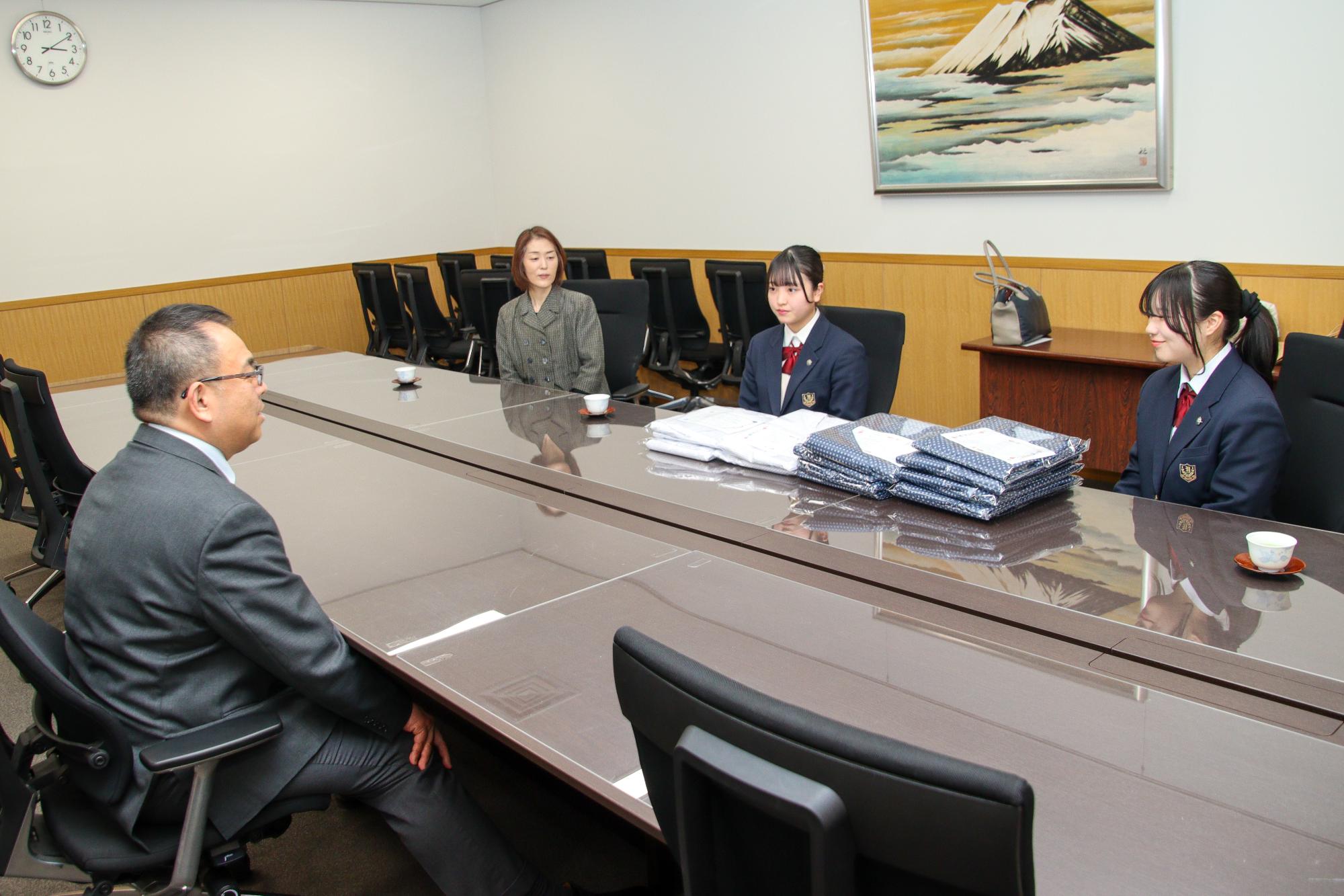 自分たちが作った「楽らくねまき」の苦労した点や感想を小川市長に話す屋代南高校ライフデザイン科2年生の山崎さん渋沢さん