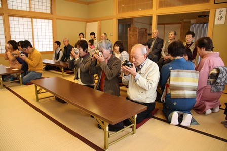 和室内で正座し、抹茶を飲む人々の写真