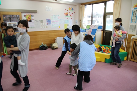 先生たちが作った手のアーチにお母さんと子供が捕まった写真
