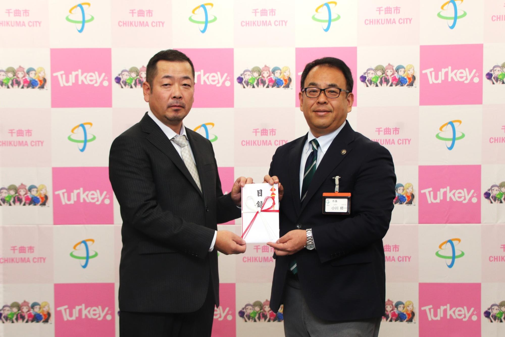 目録贈呈(左から株式会社アンジック藤倉大輔代表取締役、小川修一市長)