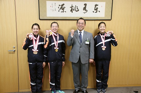 メダルを首から下げた選手たちが市長と記念撮影をしている写真