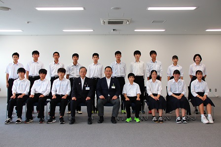 制服姿の生徒たちと市長、教育長が並んで記念撮影をしている写真