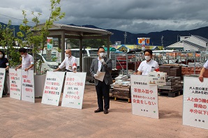 横一列に並んで看板を手に持ち啓発活動をしている人達の写真