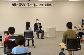 広々とした会議室で市長と参加者たちが意見交換を行っている写真