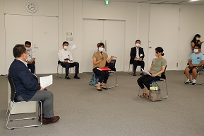 資料を手に持ちながら意見交換を進める市長と参加者たちの写真