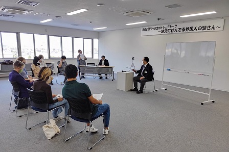 ホワイトボードのある室内で集まった参加者と市長が意見交換を行う写真
