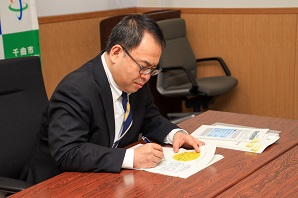 まなびばちくまが作成した資料を確認する小川市長