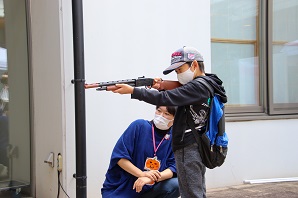 帽子を被った男の子が射的をしている写真
