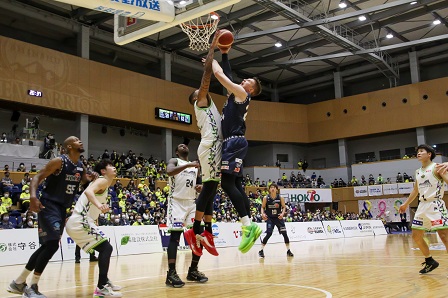 選手がボールをゴールにシュートする瞬間の写真