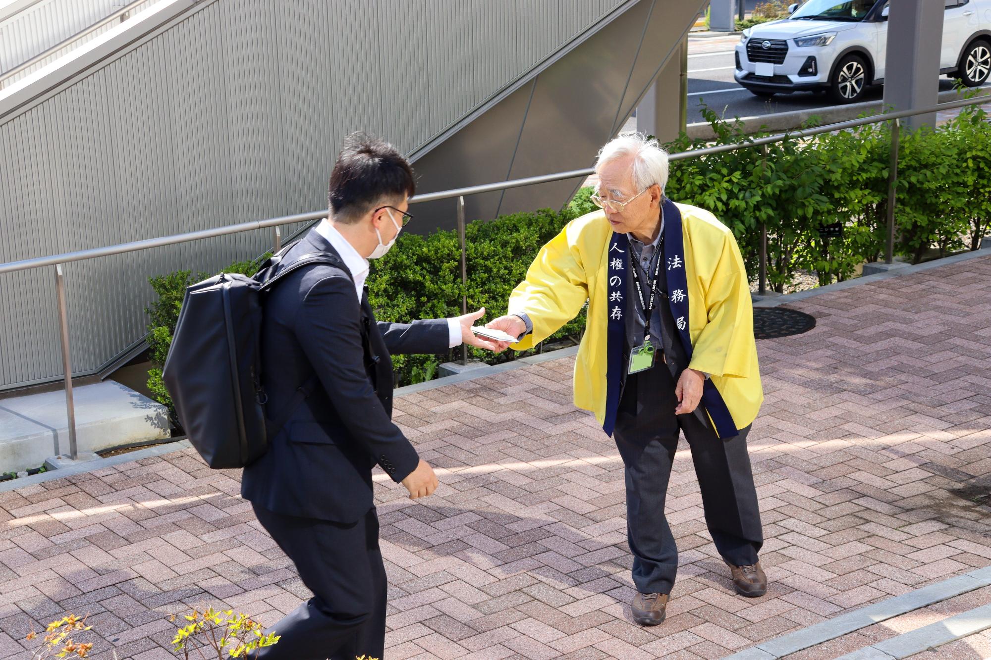 人権啓発委員からチラシを受け取る市職員