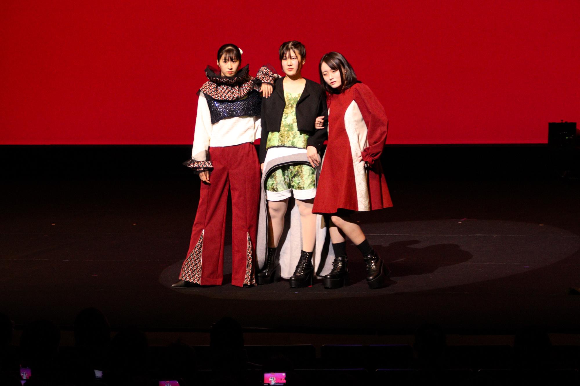 ファッションショーでポーズを決める女子生徒3名