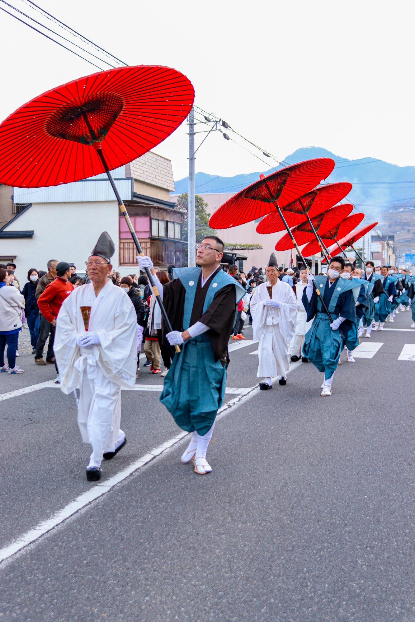 頭人ら6人の役人が笠を持った付き人と練り歩く