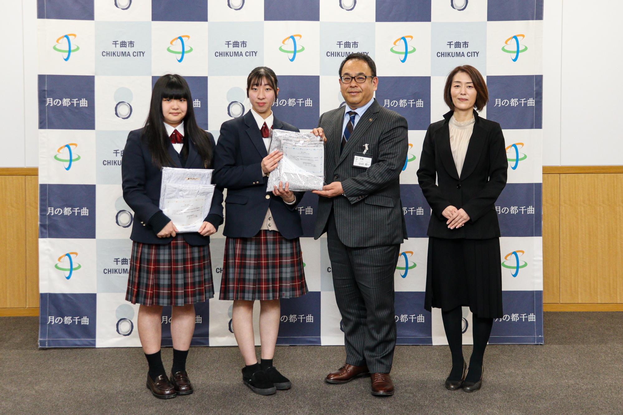 須田さん、伊藤さん、小川市長、柿崎教諭の4人でねまきを持って記念撮影