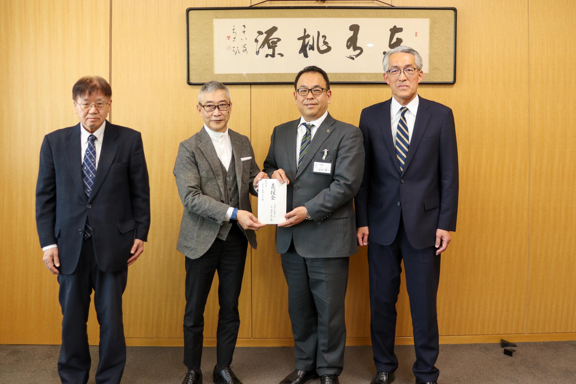 義援金の目録を持って記念撮影(左から久保田さん、矢島会長、小川市長、滝沢実行委員長