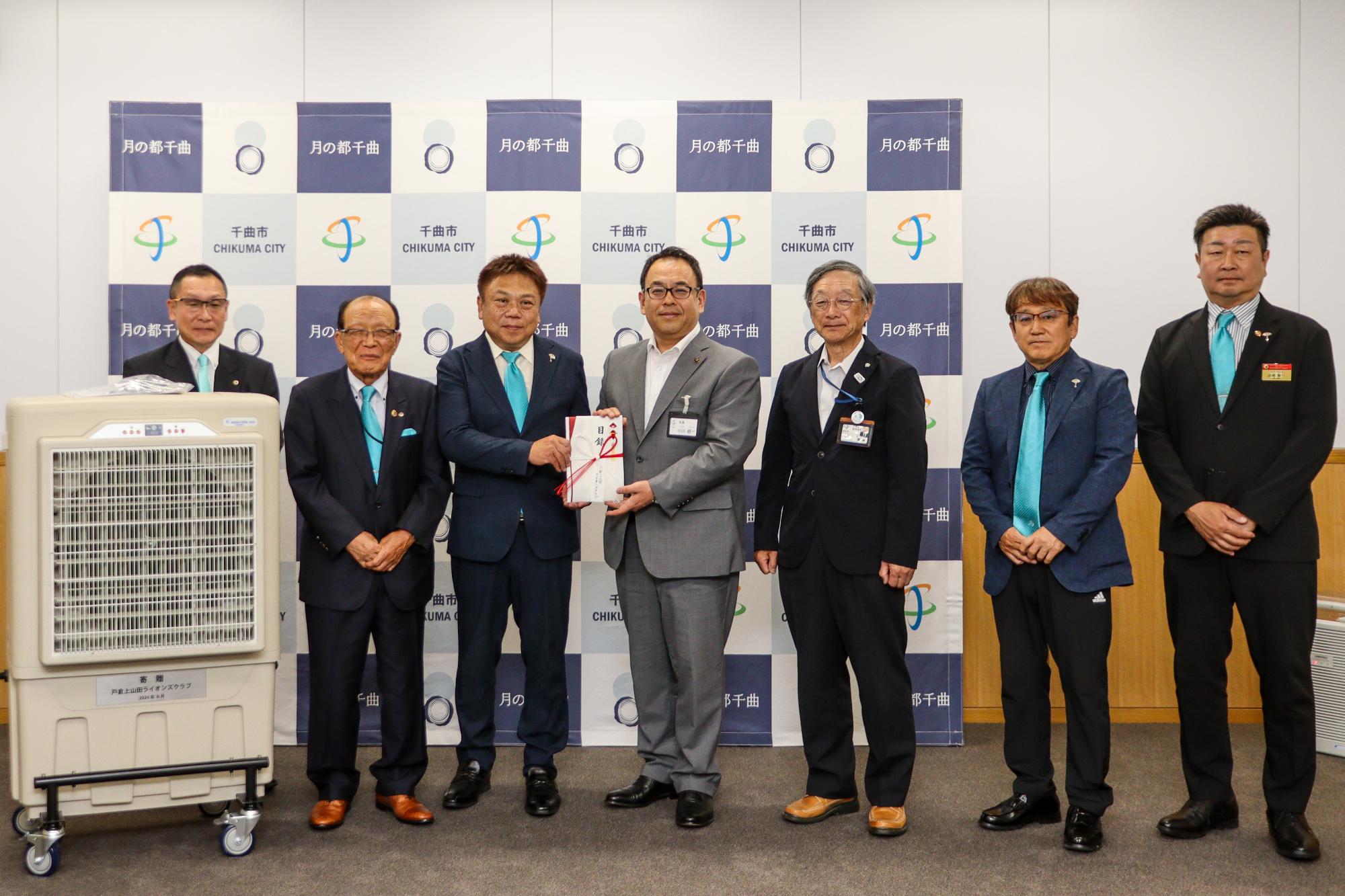 戸倉上山田ライオンズクラブの皆さん、市長、教育長が目録を持って記念撮影
