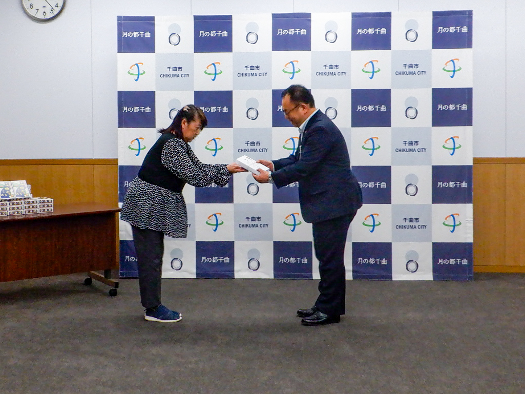 実行委員会伊藤会長から小川市長に千曲かるたが贈呈される様子