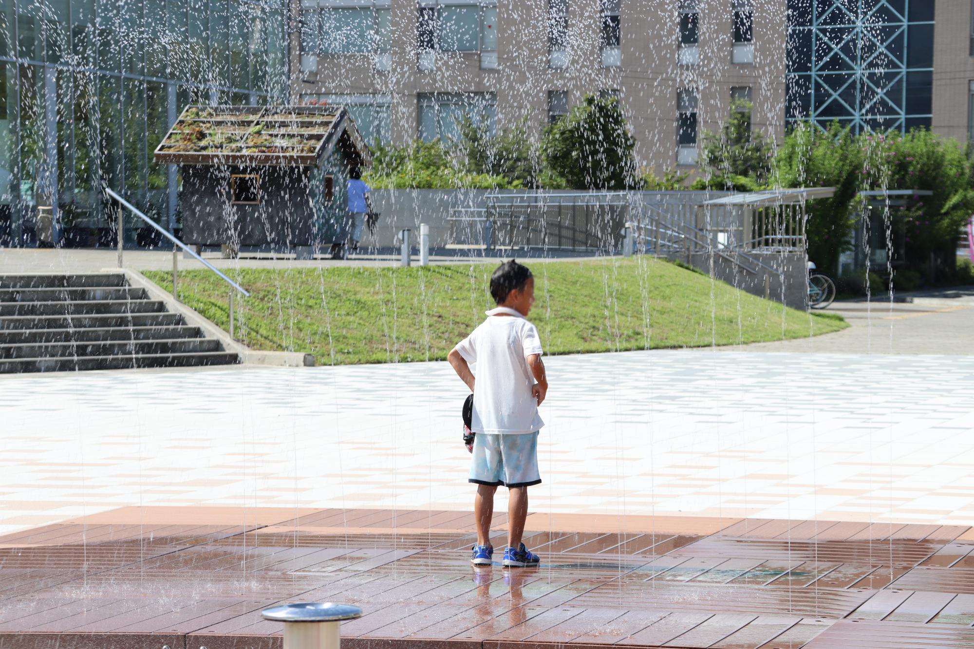 水遊び場で遊ぶ少年