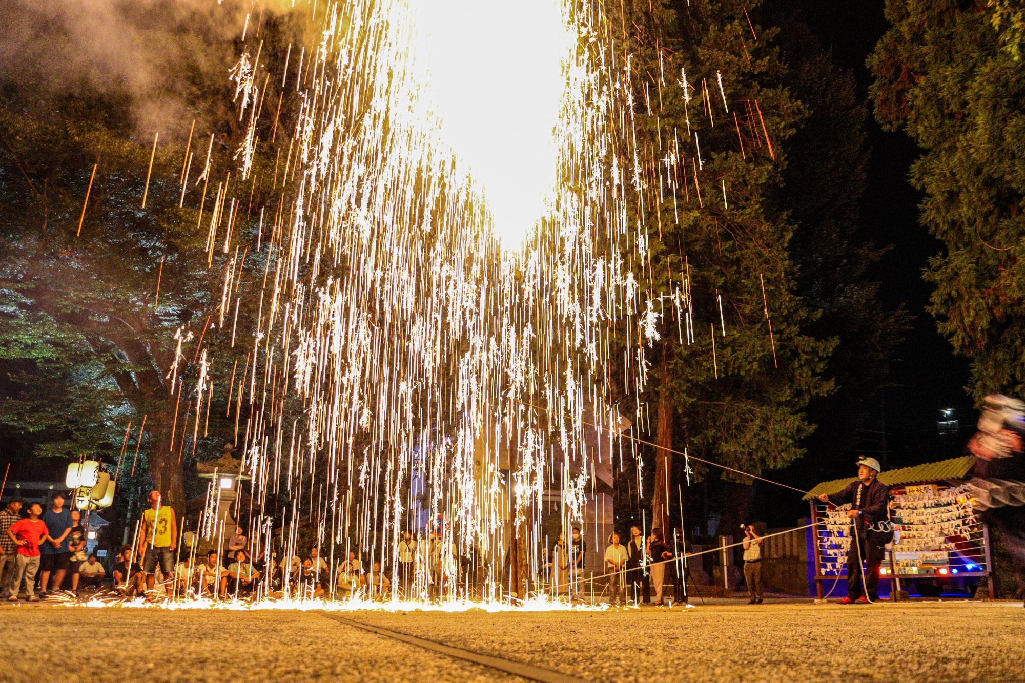 祭り最後の吹き出し花火とそれを見守る人々