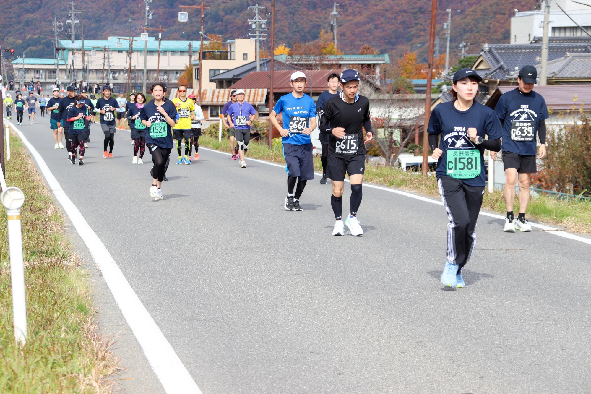 白鳥園付近の堤防道路でランナー数十名が走っている様子。