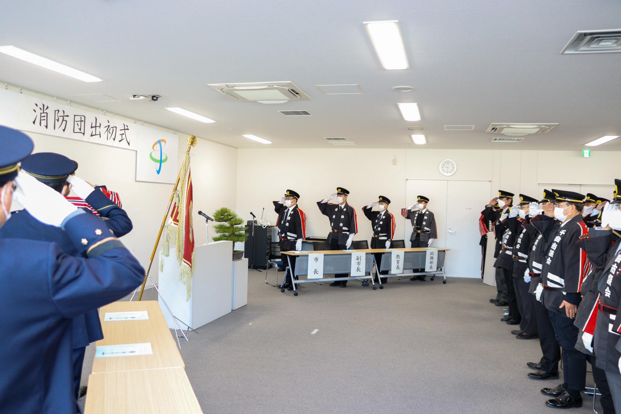 正面に向かって敬礼する一同