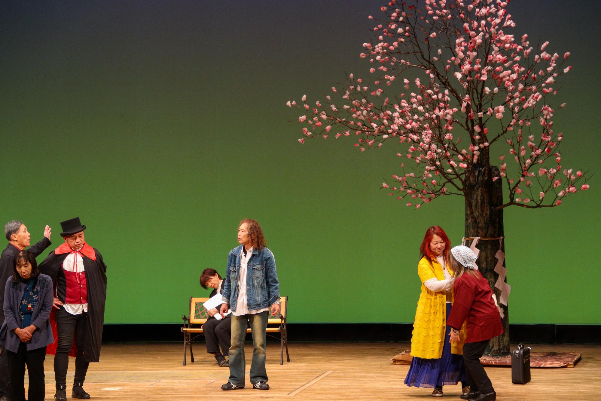 ご神木のあんずの樹の前で話し合う人々