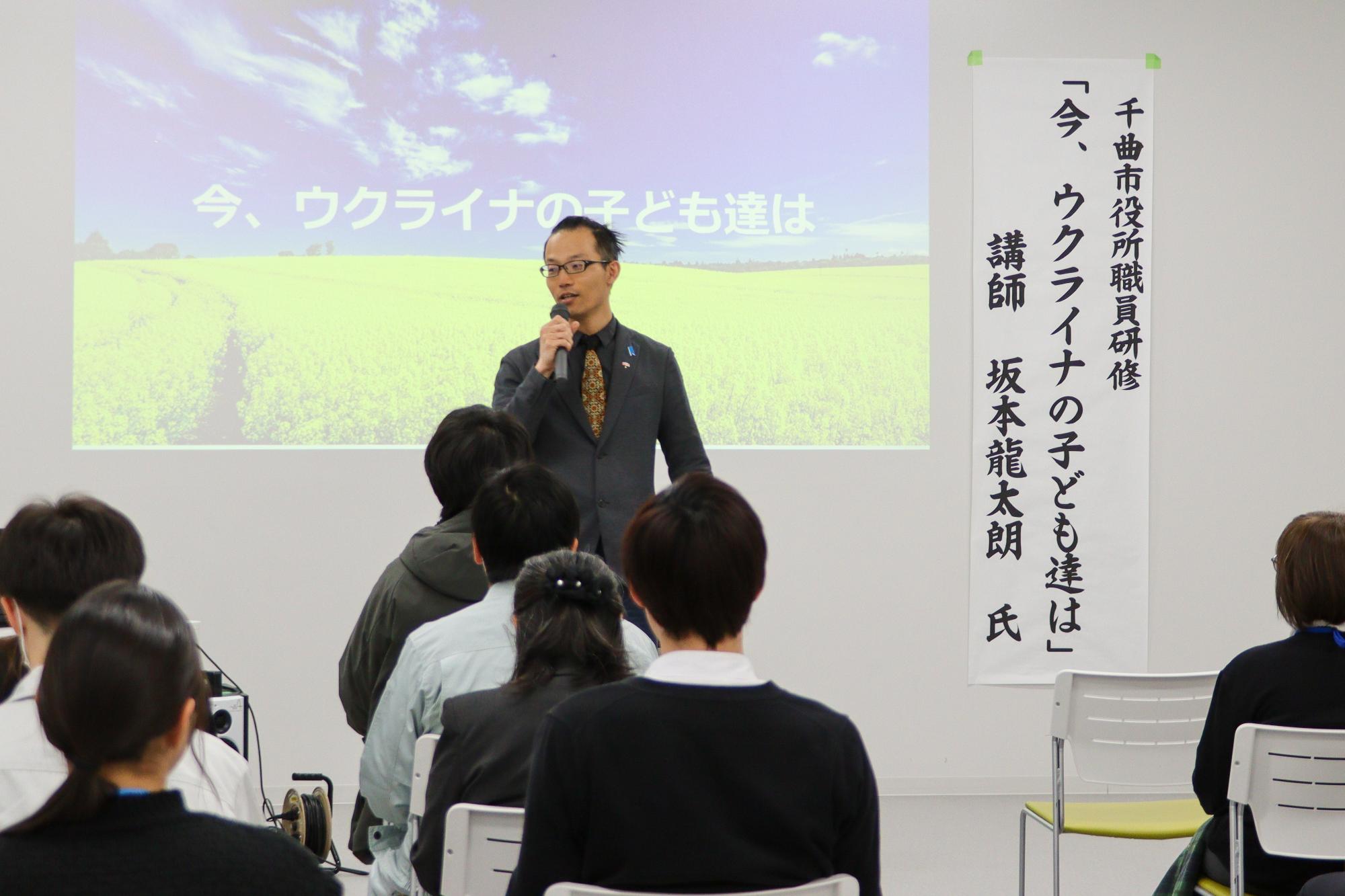 市職員の前で講演する坂本さんを参加者の後ろから撮影