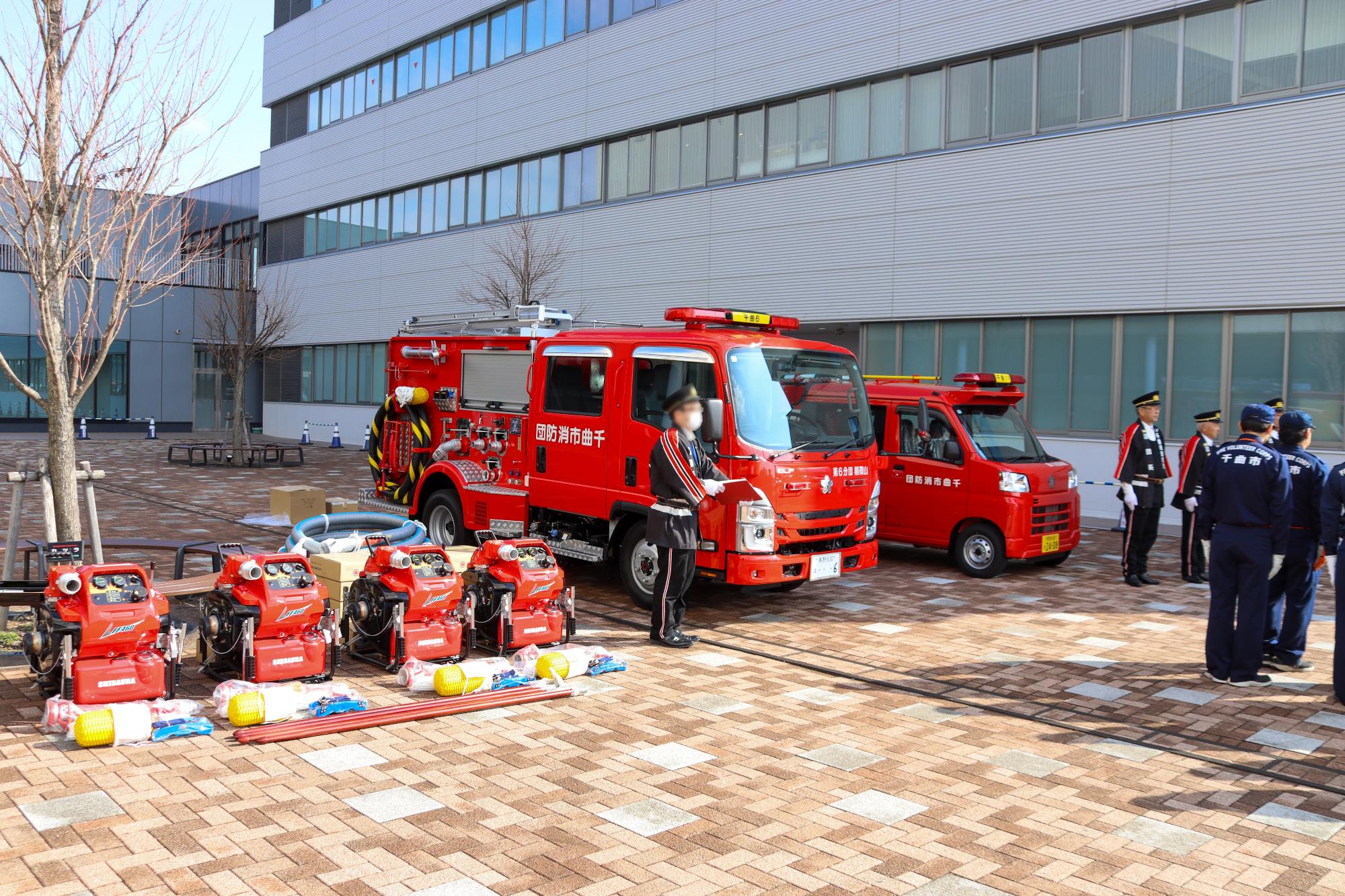 左からポンプ4台、ポンプ車と小型積載車が横一列に並んでいる様子