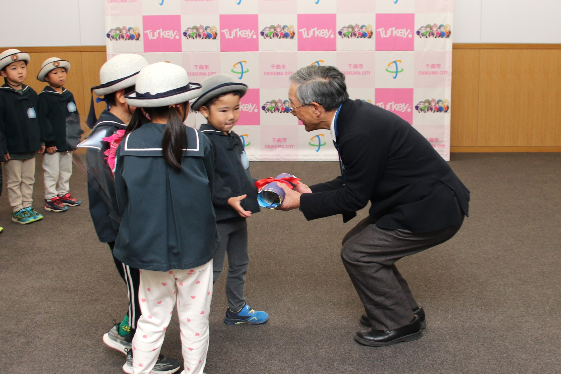 代表園児3名によるシクラメン、手作りカレンダー贈呈の様子