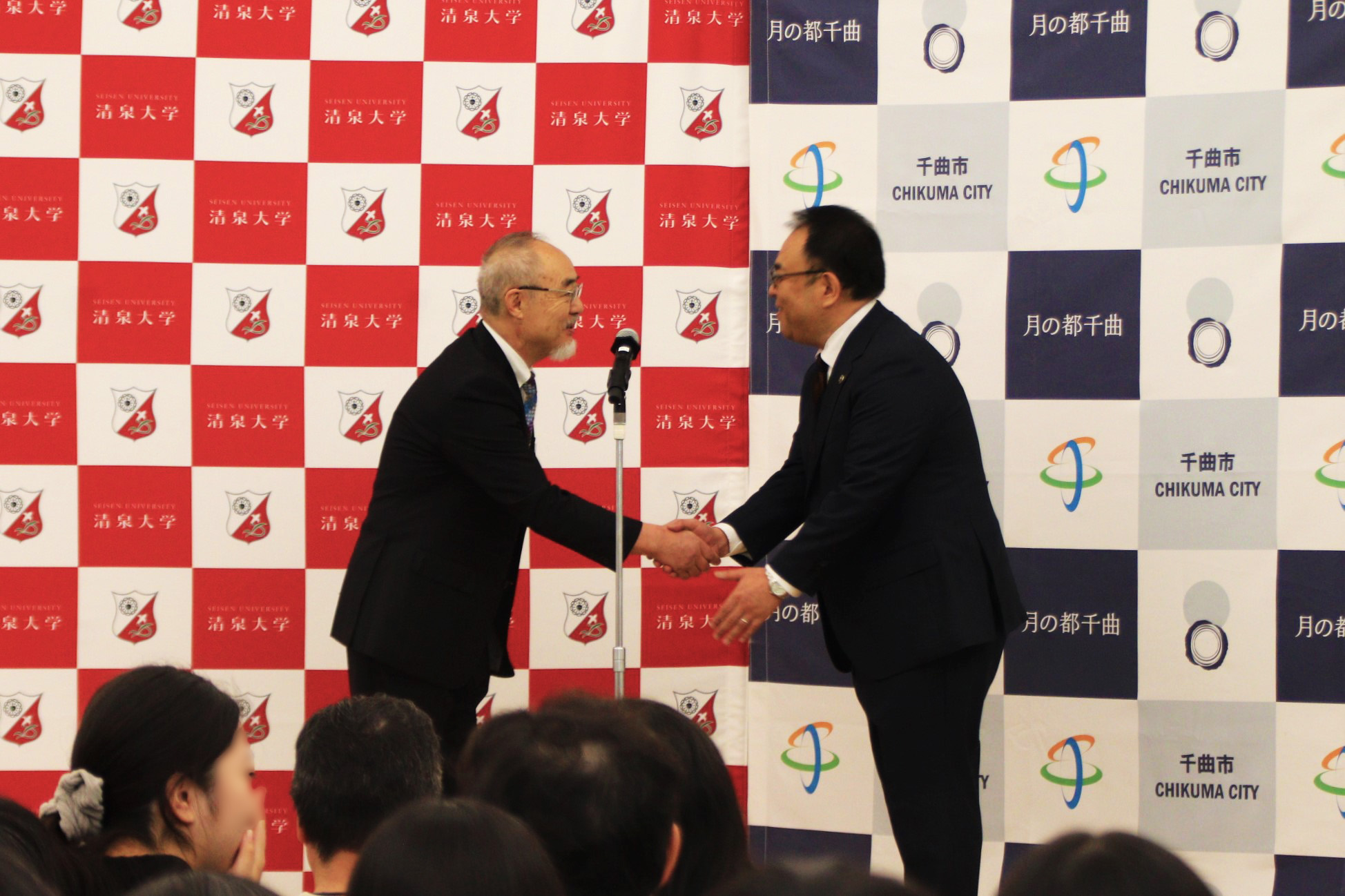 オープニングセレモニーで握手を交わす清泉大学田村学長(左)と小川修一市長(右)