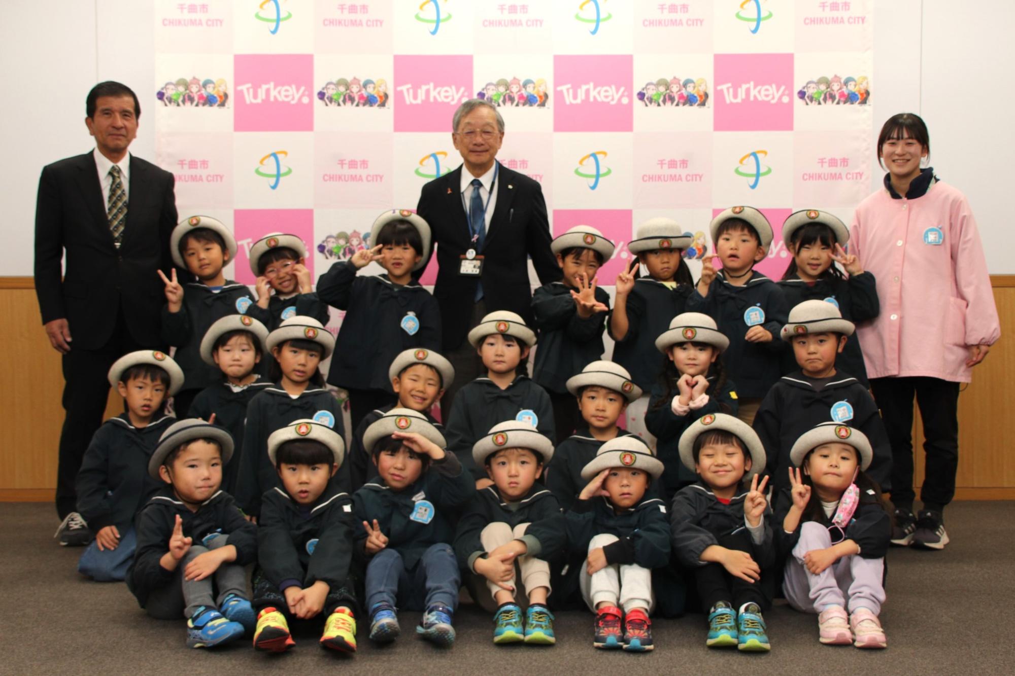 記念写真(左奥:さゆり幼稚園若林園長、中央奥:小松教育長、右奥:さゆり幼稚園担任成澤先生、手前:さゆり幼稚園園児22名)