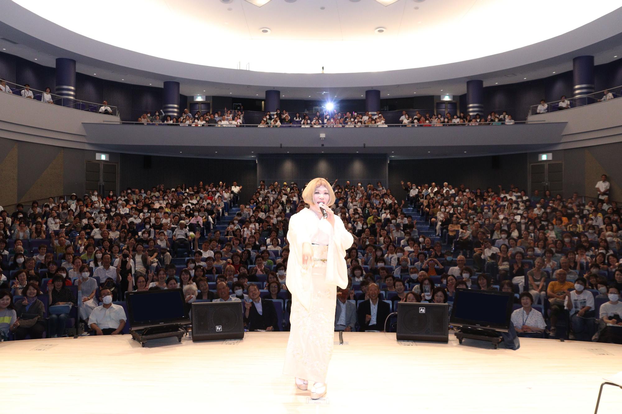 客席をバックに撮影したIKKOさんの画像