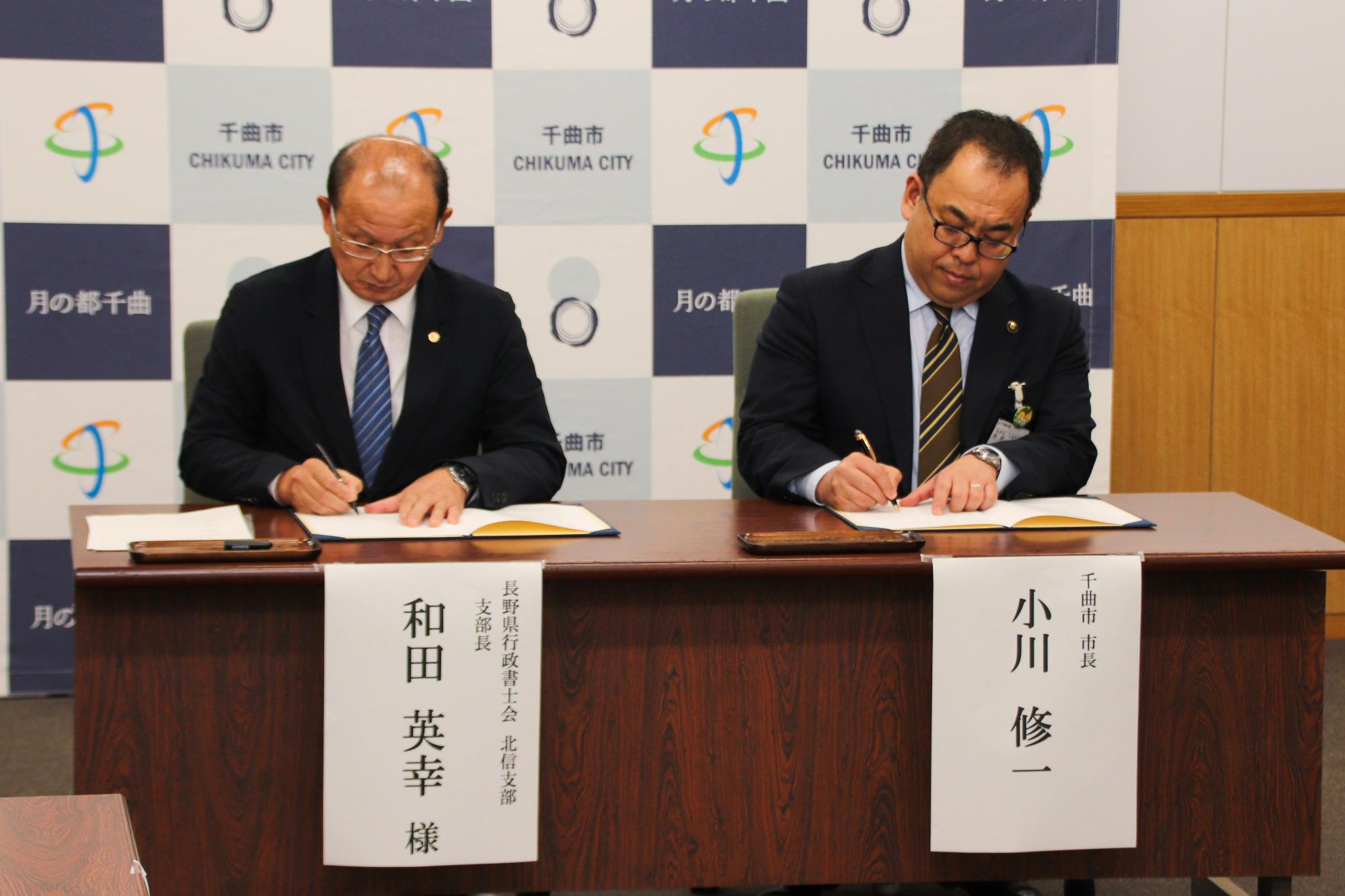 協定書にサインする小川市長と和田支部長