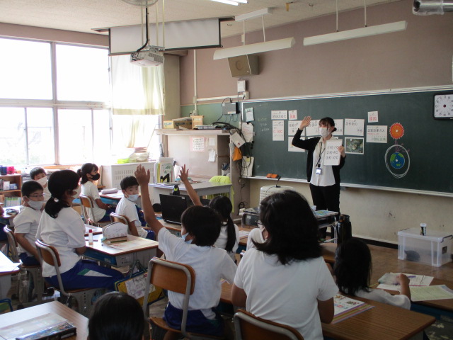 手を挙げている児童数名と先生が向かい合う授業風景の写真
