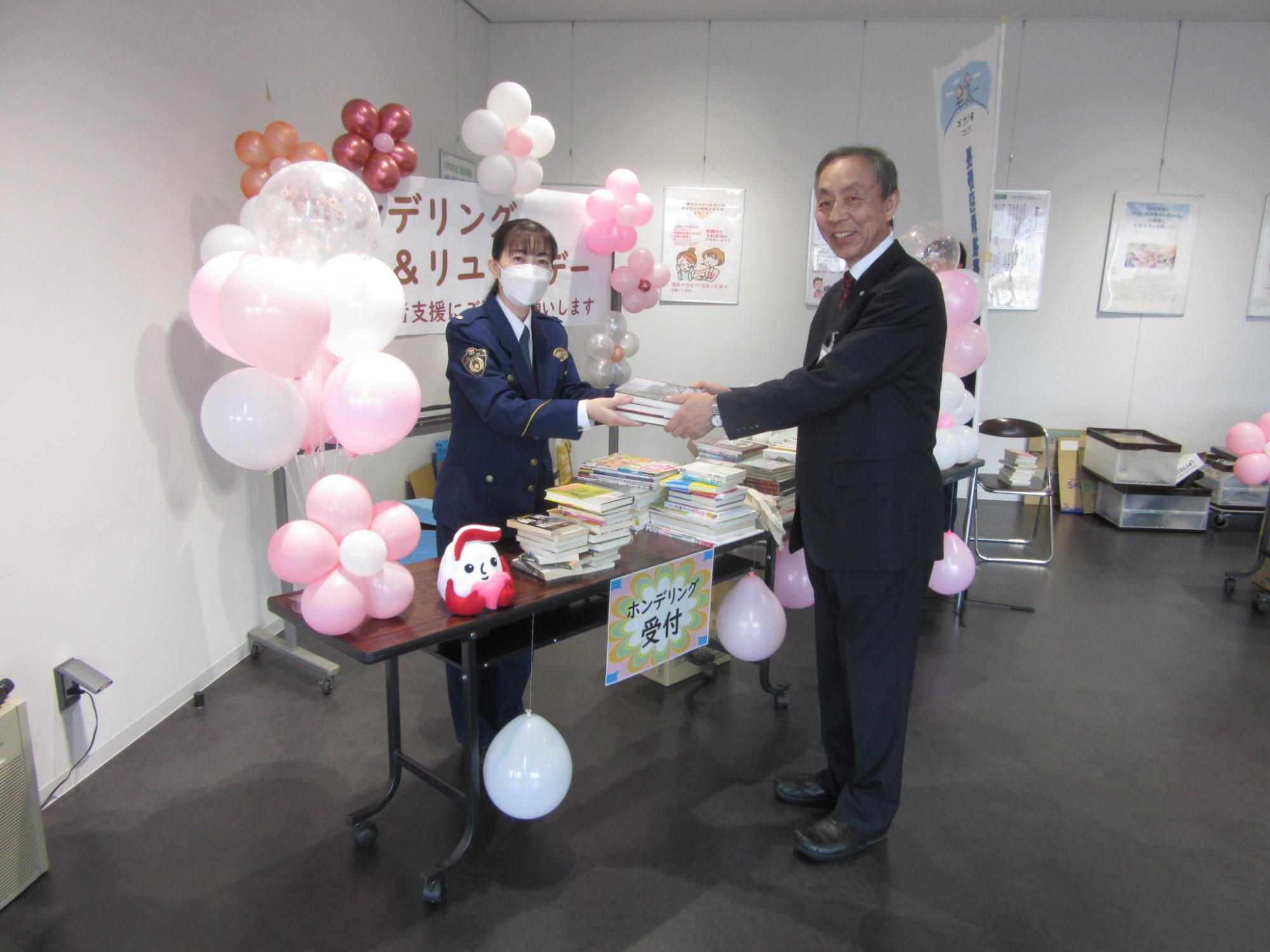 副市長が本を寄付する様子