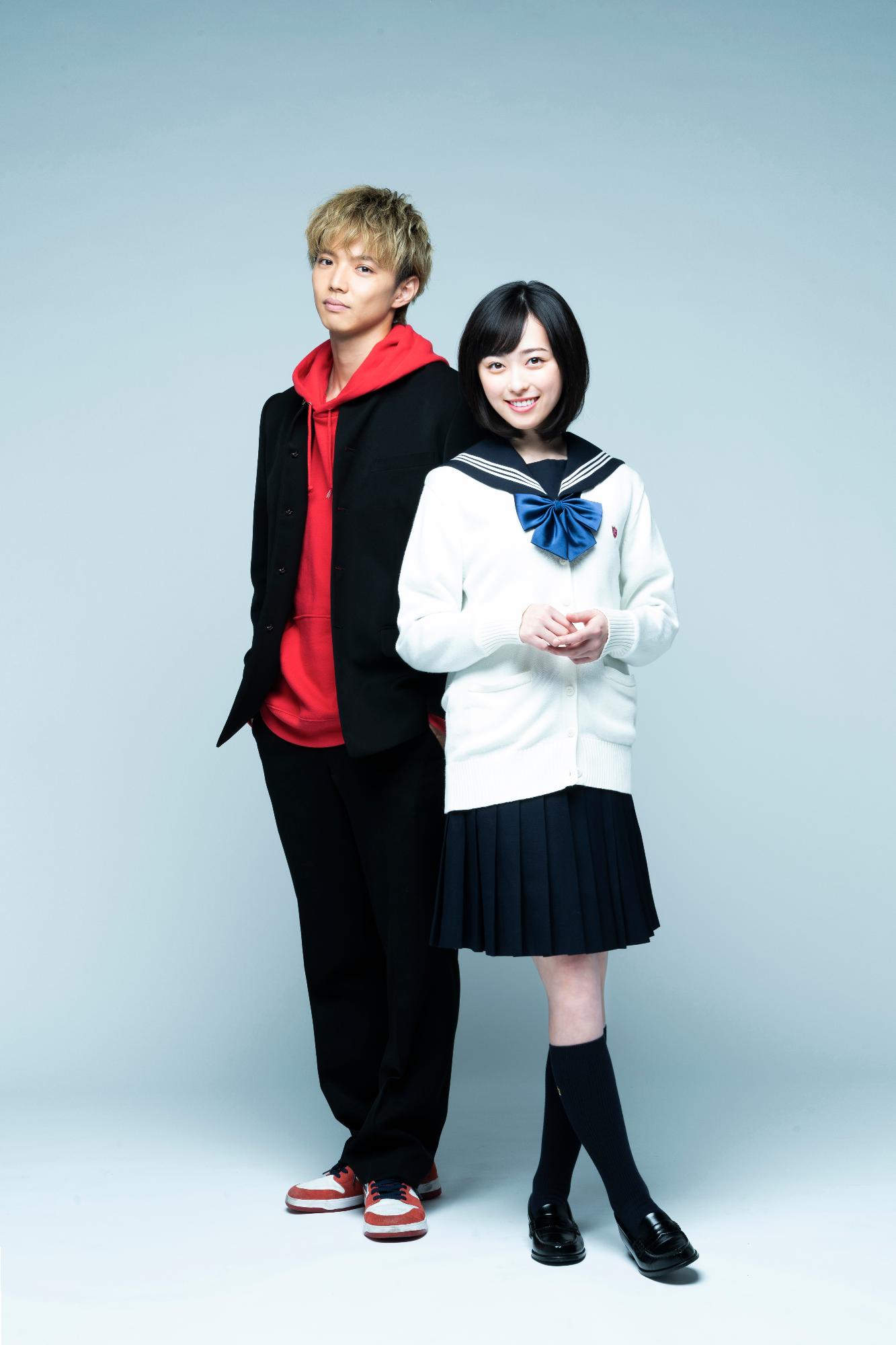 薄青色の背景を背にして、女子高校生と男子高校生に扮して並んでいる二人の演者の写真